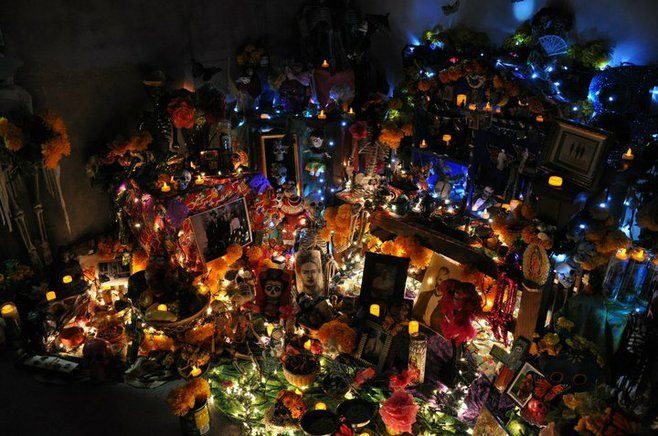 A candlelit altar at the Center in 2010, crowded with marigolds, framed photographs and glowing votives