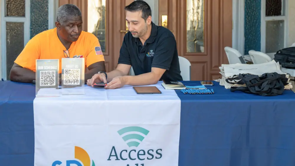 A digital navigator helping a resident at an SD Access 4 All outreach table