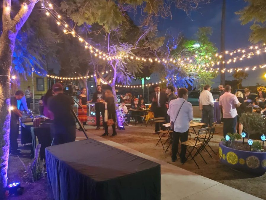 Guests mingling under strings of lights in the courtyard at dusk